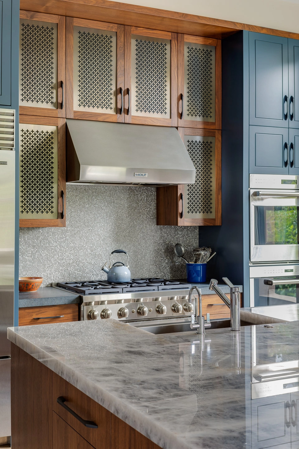 Kitchens, Baths, and Mechanicals - Luxury kitchen detail with Wolf range hood and walnut mesh-panel cabinets