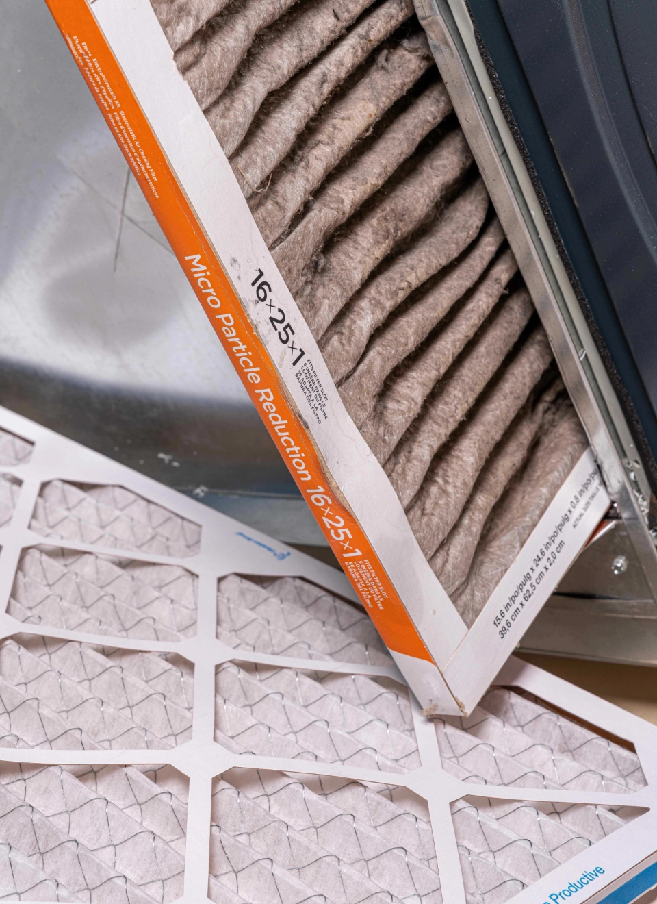 Clogged HVAC filter beside a replacement filter during scheduled mechanical servicing