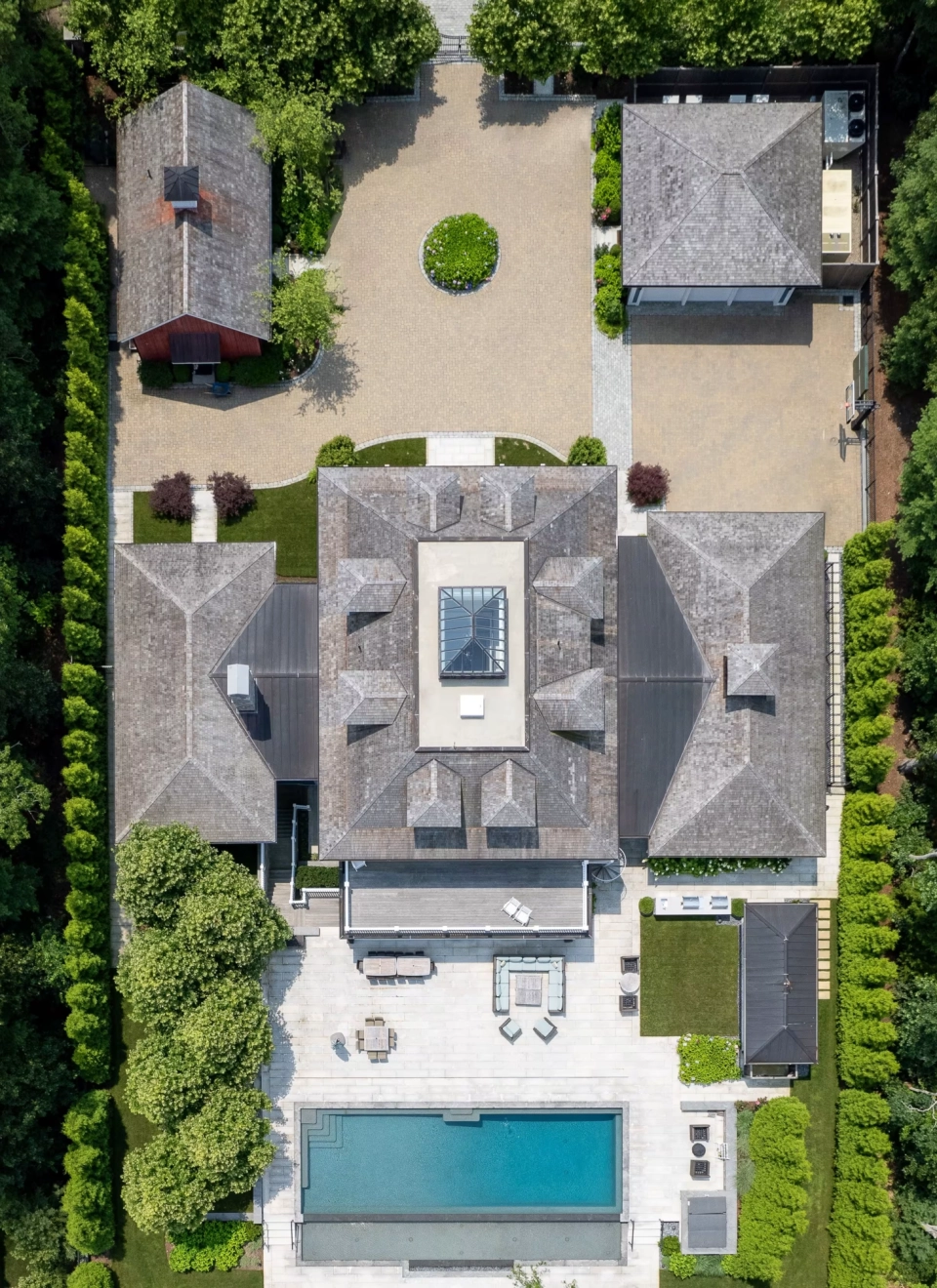 Aerial view of a New England estate with pool, pool house, and multiple outbuildings
